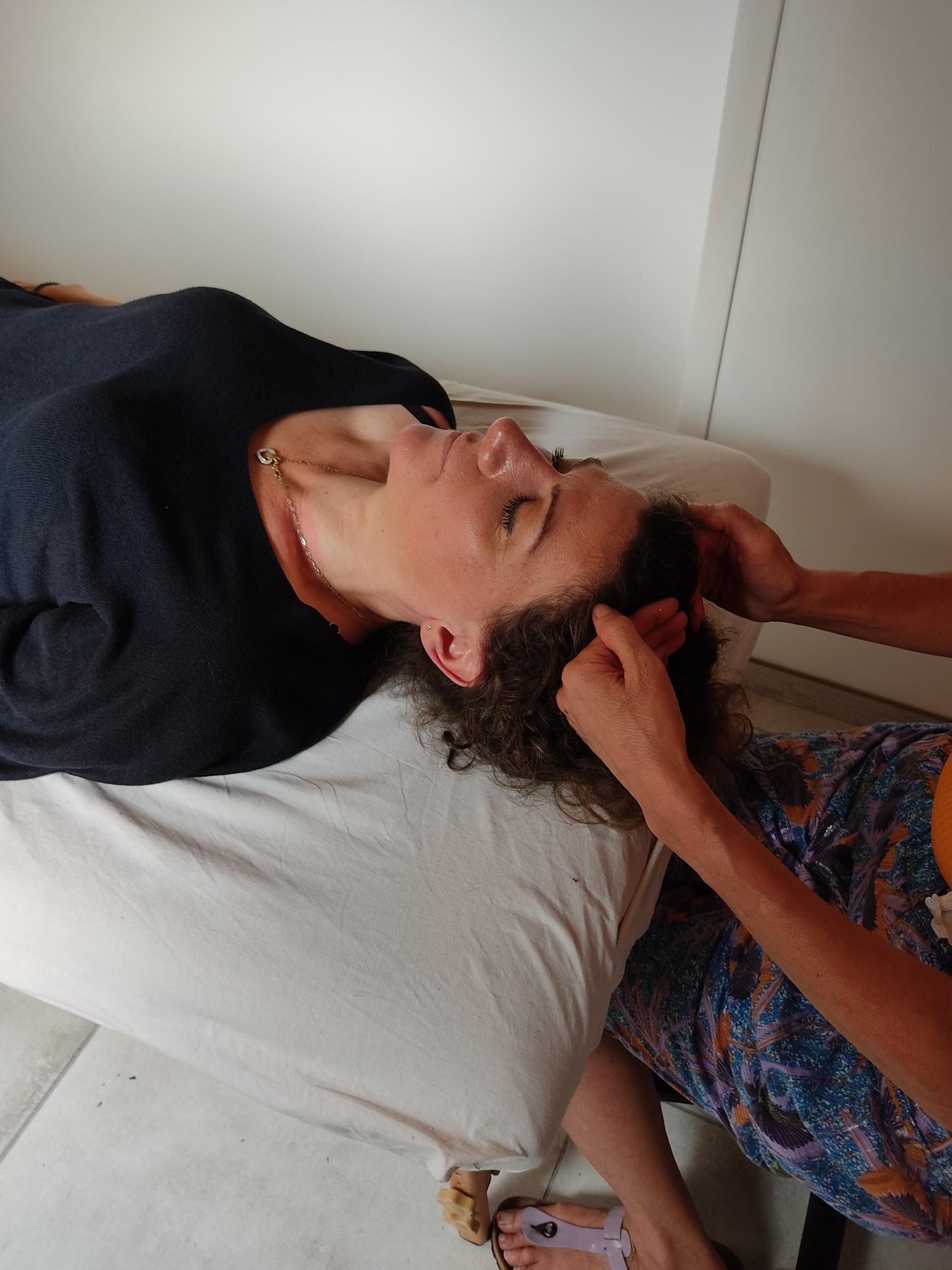 Femme allongée sur table de massage-mains posées sur la tête avec points énergétiques Access- bar