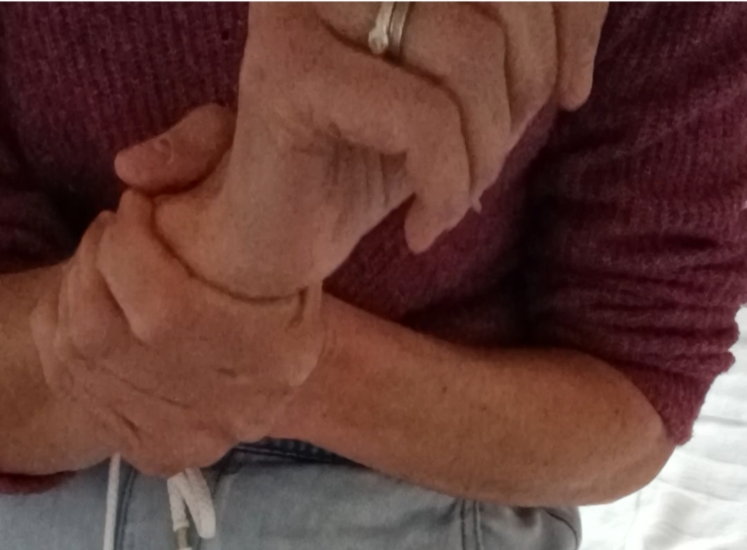 une main qui tient le poignet de l'autre main pour le masser